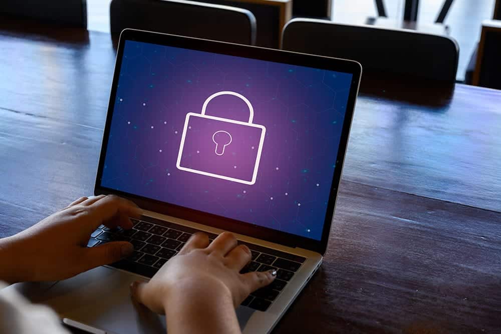 Person working at a laptop at home with lock on screen, symbolizing enterprise security remote work