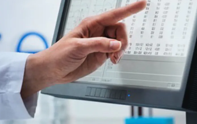 Decorative image of person in a lab coat touching a computer screen.