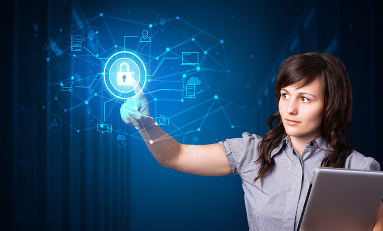 Professional woman holding a closed laptop in one arm, while she reaches out with the other arm to click on an overlayed illustration of a lock overlayed