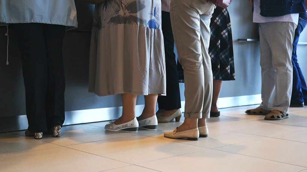 decorative image of citizens waiting in line for service at a government agency