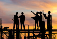 Workers standing at a construction site should collaboration between engineers, capital project managers, and operations and maintenance teams.