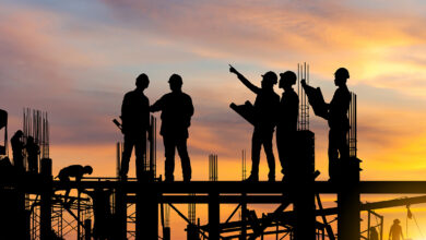 Workers standing at a construction site should collaboration between engineers, capital project managers, and operations and maintenance teams.