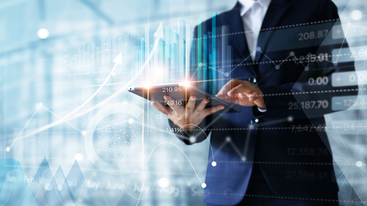 Image of a business man holding a tablet and analyzing business data.