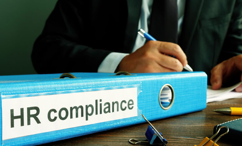 A binder with the text on the spine that reads: HR compliance