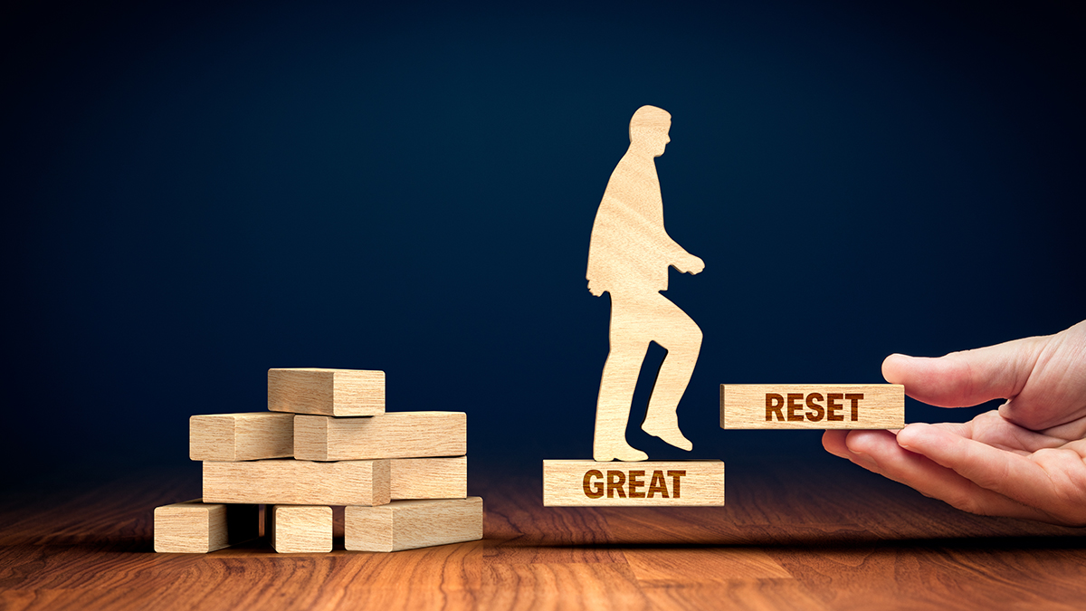 Image of a wooden person walking up a set of blocks reading The Great Reset.