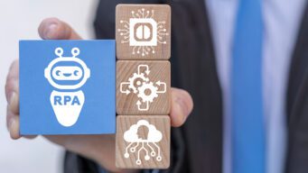 Close-up on wooden blocks with gears and a robot with the letters RPA for Robotic Process Automation.