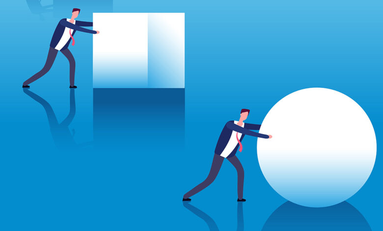 Illustration of two male professionals. One is pushing a square block and is behind the other who is pushing a sphere which symbolizes how businesses fall behind with legacy technology.