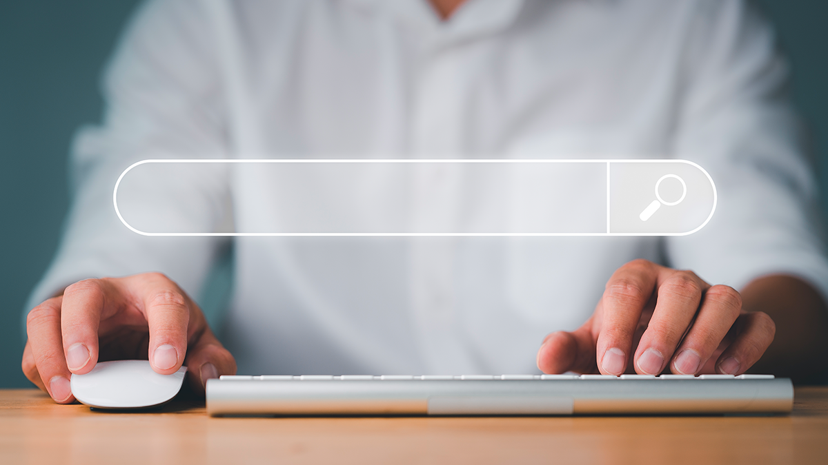 A search bar overlaid over a person with a mouse and a keyboard.