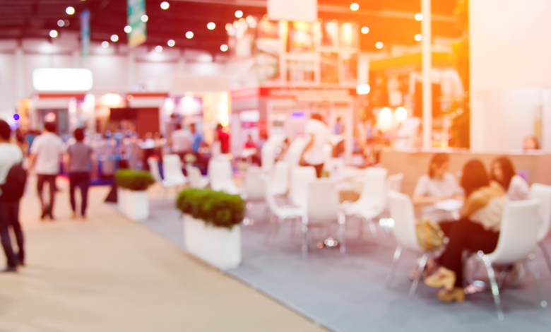 busy conference expo floor with lots of people moving about, networking and learning; slightly blurred image for background effect