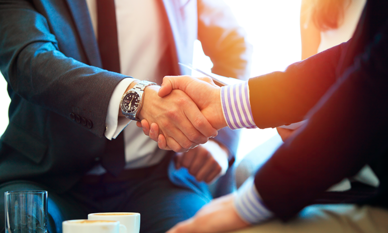Two members of the treasury department shaking hands.