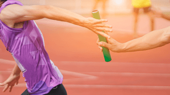 Close up of an athlete handing a baton to the next athlete in a relay race