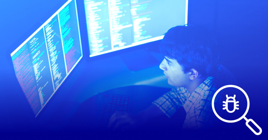 An overhead view of a man sitting at a desk with two screens. The screens have code on it, implying cybersecurity and threat hunting. The image has a blue overlay. In the bottom right corner, there is a magnifying glass symbol with a bug inside.