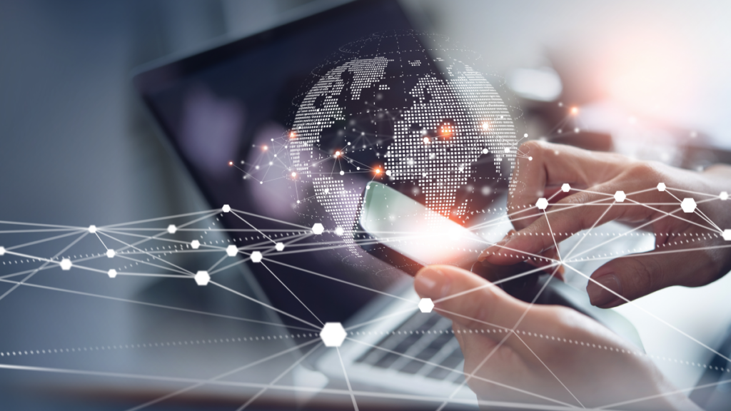 worker's hands working on mobile phone with laptop in background, icons overlay image indicating connectivity