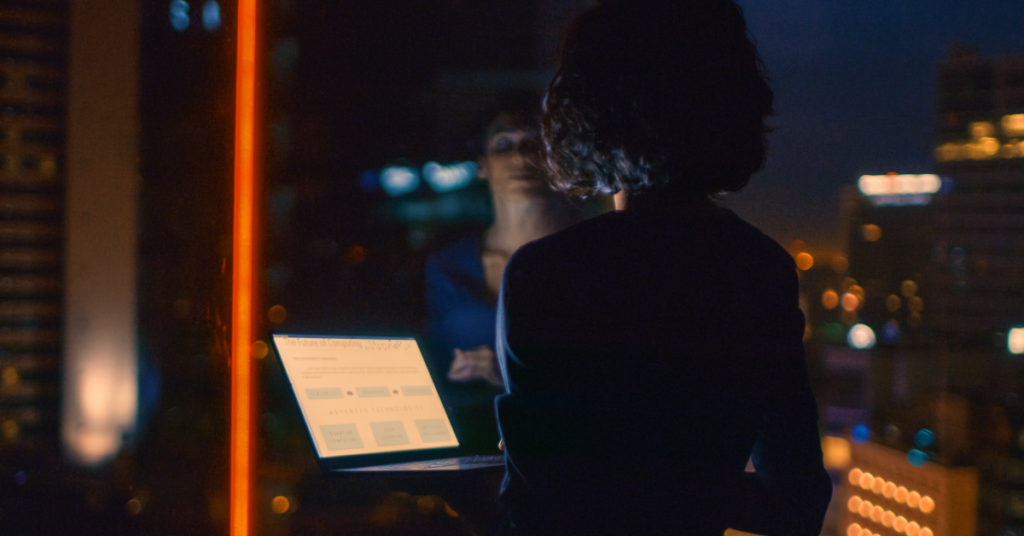 woman looking at a tablet at a window