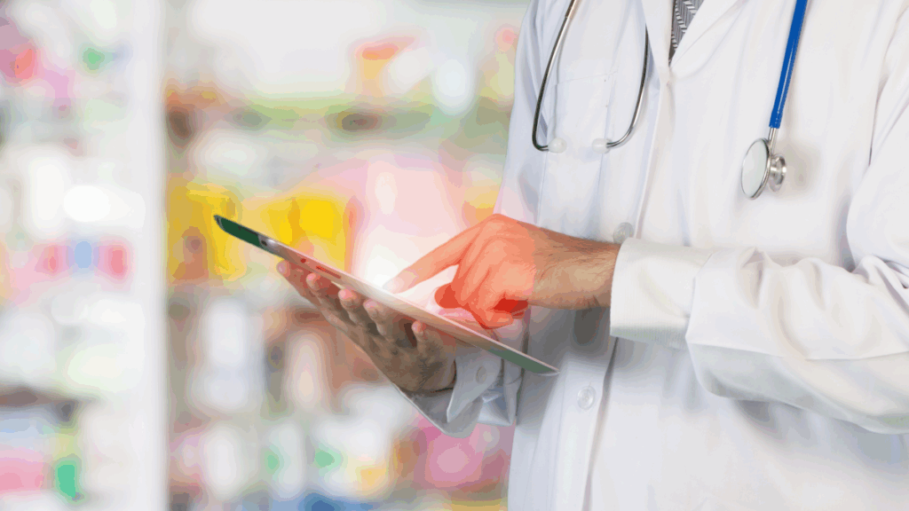 mid-shot of medical person or pharmacist using a tablet with shelves of medications in background showing importance of devsecops processes