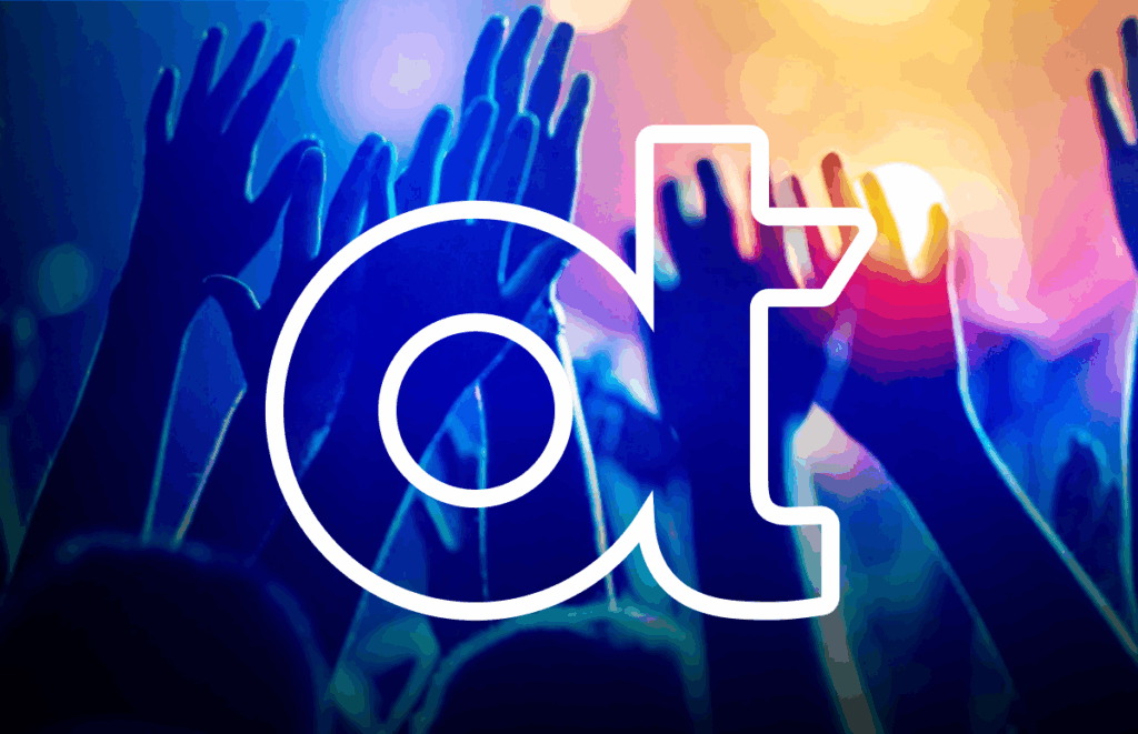 hands raised at a concert with OT logo in front