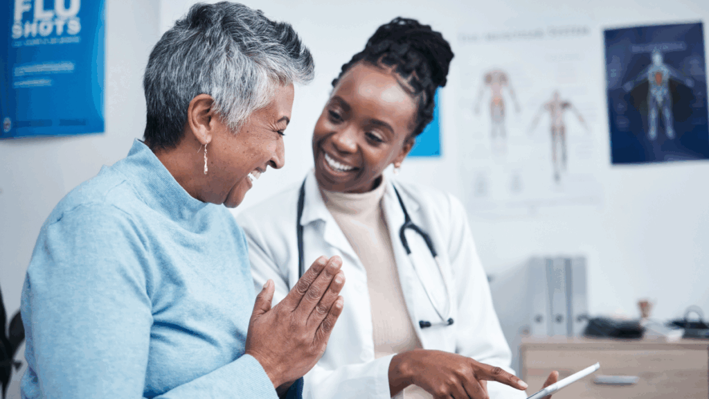 female doctor and patient smile as they point at tablet, reassured by devops for healthcare