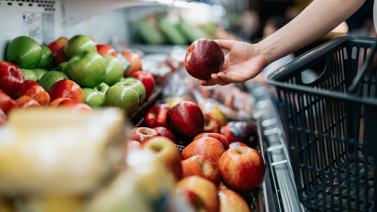 Shopper picking out apples at grocery store