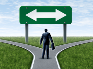 man with a briefcase at a fork looking at arrows pointing left and right