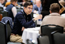 Two businessmen talking at a table during a conference