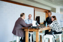 business people talking around a table at a conference